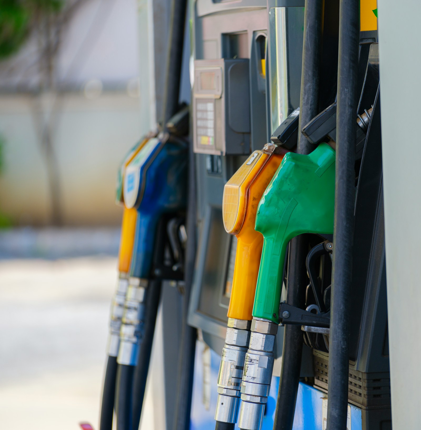 Row of fuel dispenser nozzles at a gas station